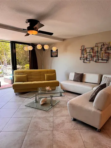 a living room with furniture and three windows