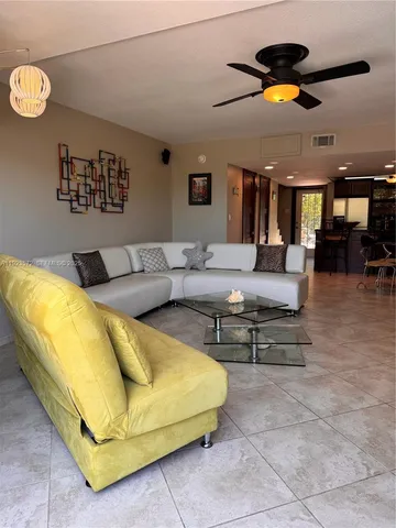 a living room with furniture and a ceiling fan