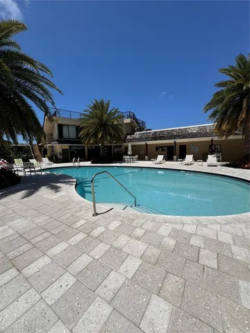 a view of swimming pool with lawn chairs and plants