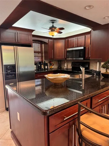 a kitchen with stainless steel appliances granite countertop a sink a stove and a refrigerator