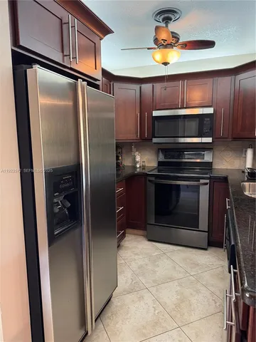 a kitchen with stainless steel appliances granite countertop a refrigerator and a stove top oven