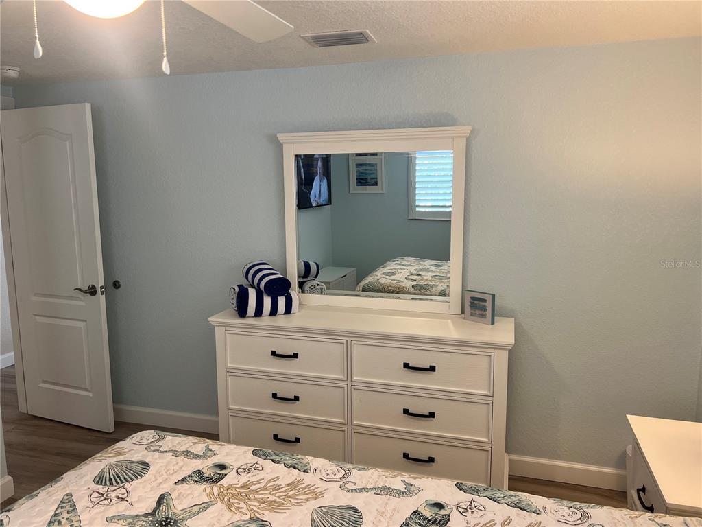 6154 Midnight Pass Road, Unit D16 Sarasota, FL 34242 - Photo 11 of 12 a bedroom with a bed and a dresser