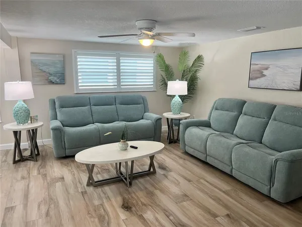 a living room with furniture and a wooden floor