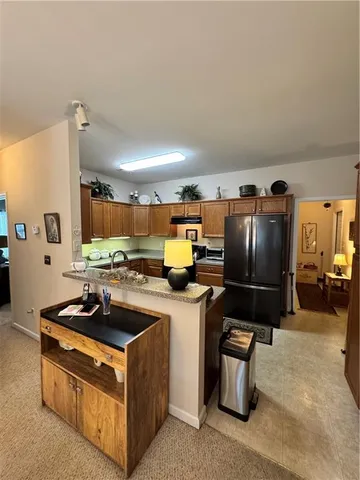 a kitchen with furniture a refrigerator and a stove