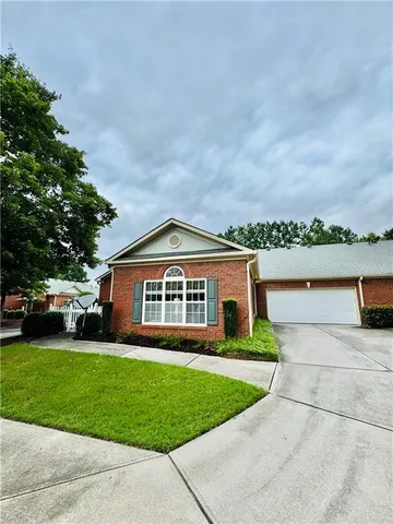 a front view of a house with a yard and lake view
