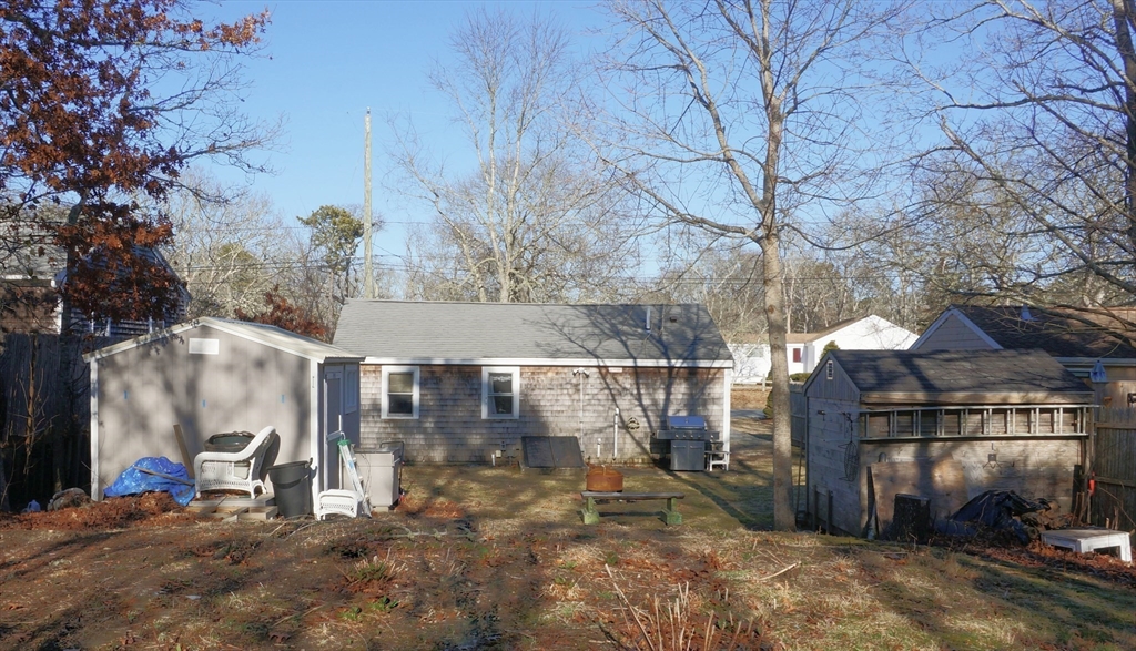 9 Circuit Road West Yarmouth, MA 02673 - Photo 18 of 23 a view of a white house with a large tree and wooden fence