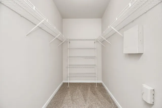 a view of walk in closet with empty racks
