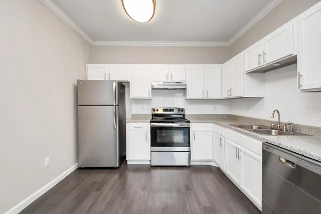a kitchen with a refrigerator stove and white cabinets