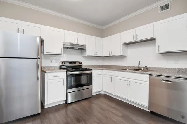 a kitchen with granite countertop white cabinets and white appliances