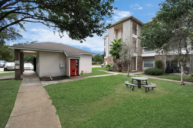 a view of a house with backyard and sitting area