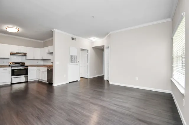 a view of a kitchen with wooden floor and a window