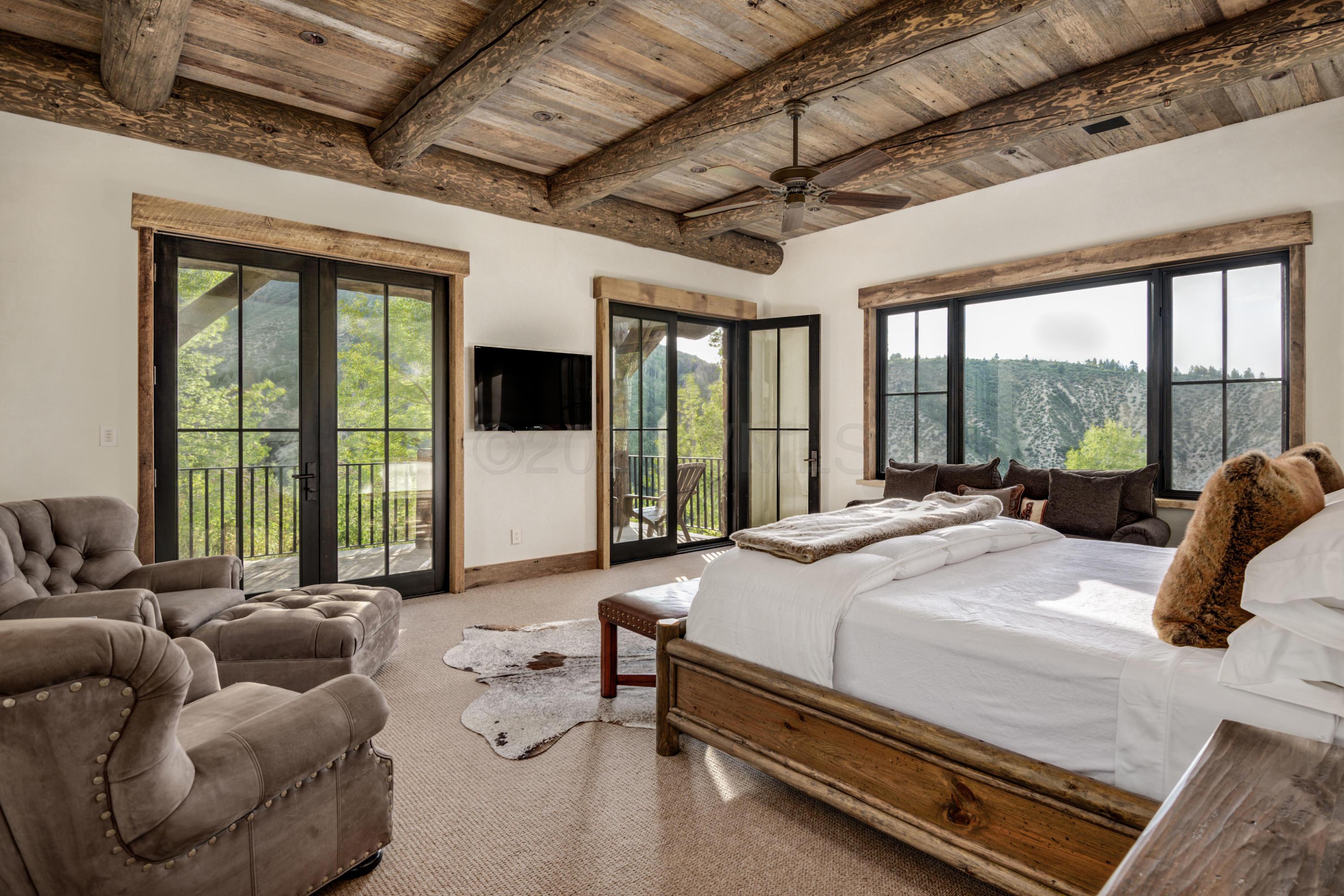 1580 Cresta Road Edwards, CO 81632 - Photo 18 of 25 a bedroom with furniture and large windows