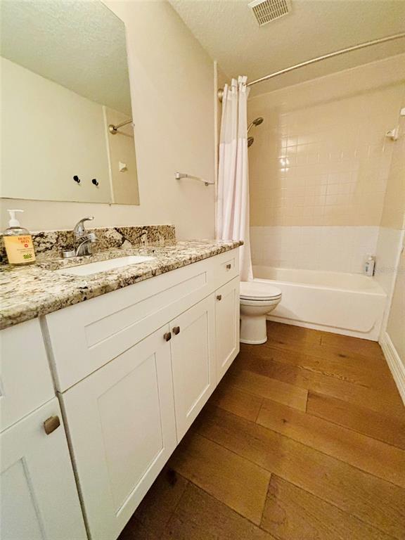 1045 Shaffer Trail Oviedo, FL 32765 - Photo 13 of 30 a bathroom with a granite countertop sink a toilet and a bathtub