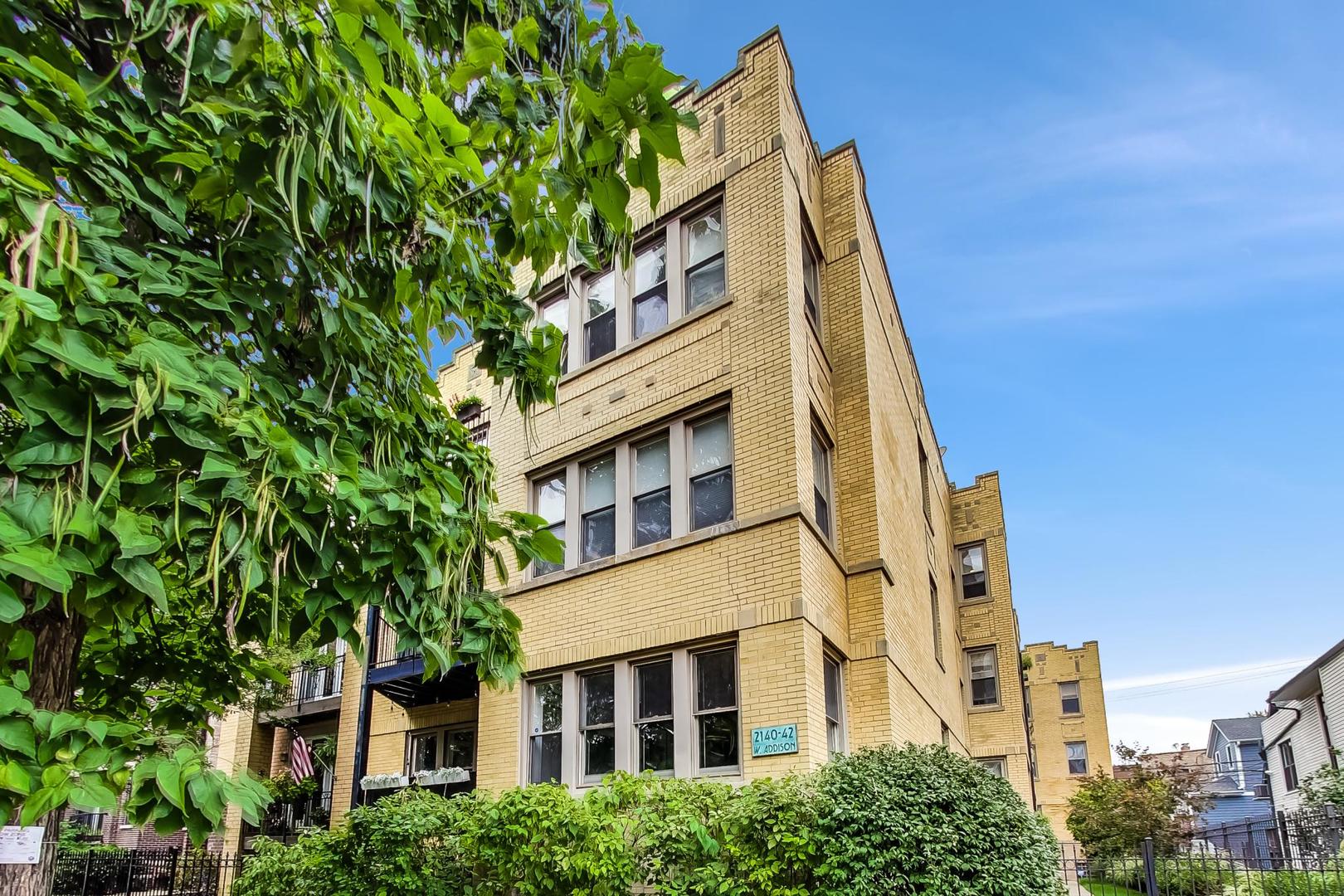 2142 West Addison Street, Unit 1A Chicago, IL 60618 - Photo 2 of 23 a view of a large building with a tree in front of it