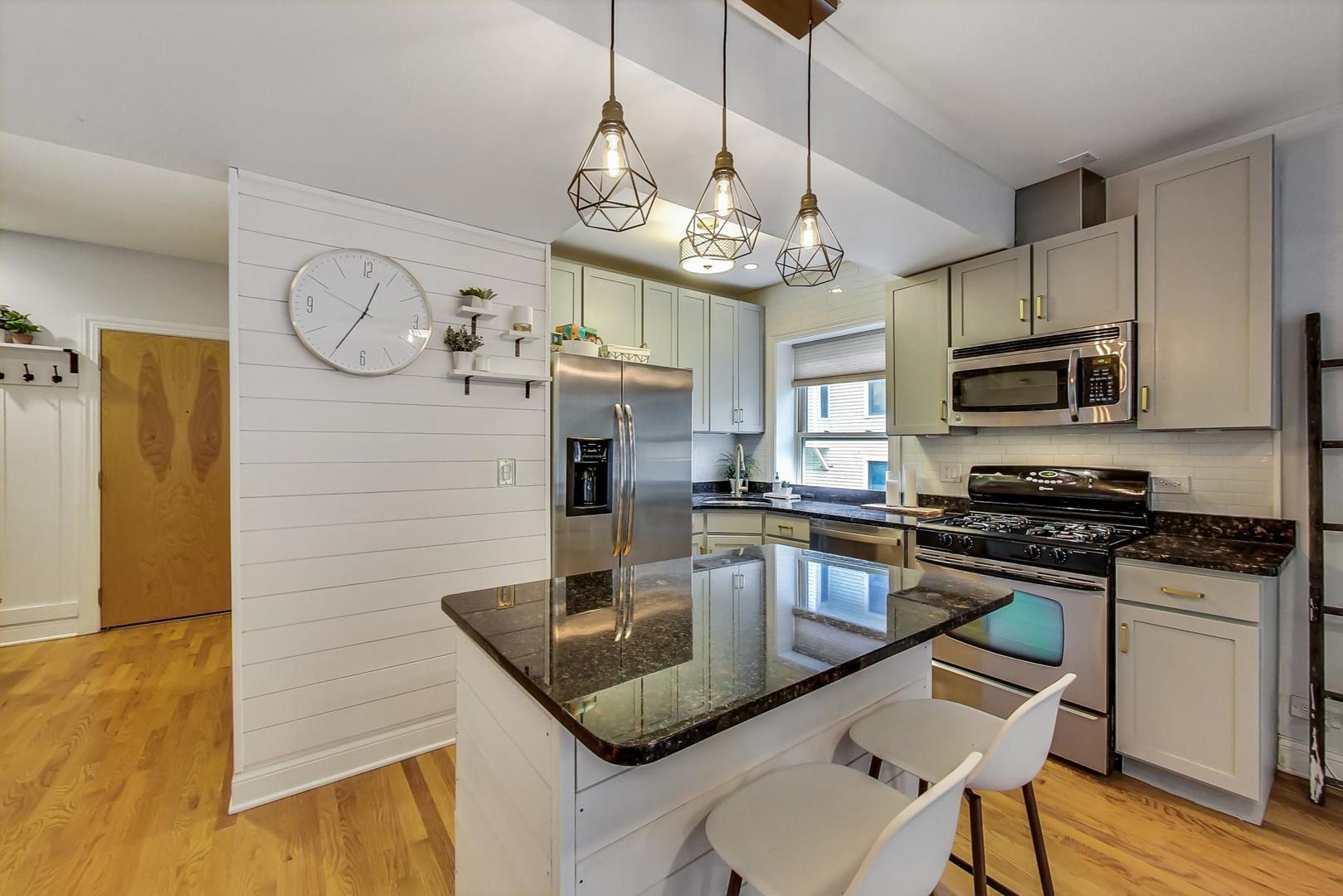 2142 West Addison Street, Unit 1A Chicago, IL 60618 - Photo 5 of 23 a kitchen with stainless steel appliances granite countertop a sink a stove and refrigerator