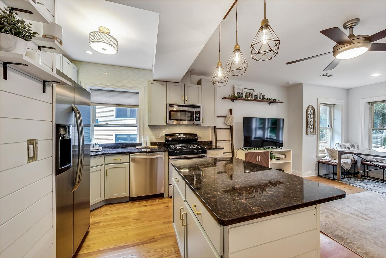 2142 West Addison Street, Unit 1A Chicago, IL 60618 - Photo 6 of 23 a kitchen with stainless steel appliances granite countertop a sink a stove and cabinets
