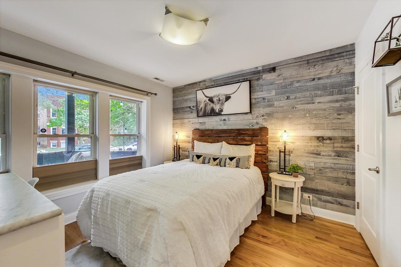 2142 West Addison Street, Unit 1A Chicago, IL 60618 - Photo 8 of 23 a bedroom with a bed and a large window with the outer view