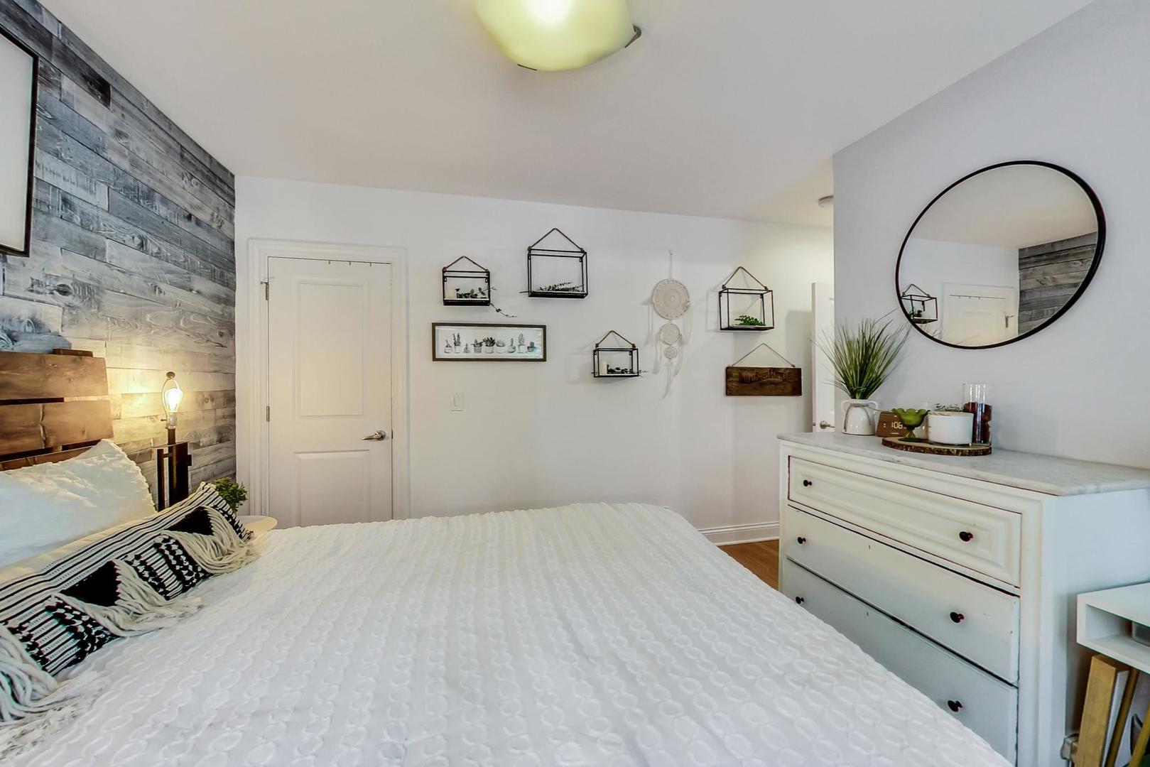 2142 West Addison Street, Unit 1A Chicago, IL 60618 - Photo 9 of 23 a bedroom with a bed and a chandelier