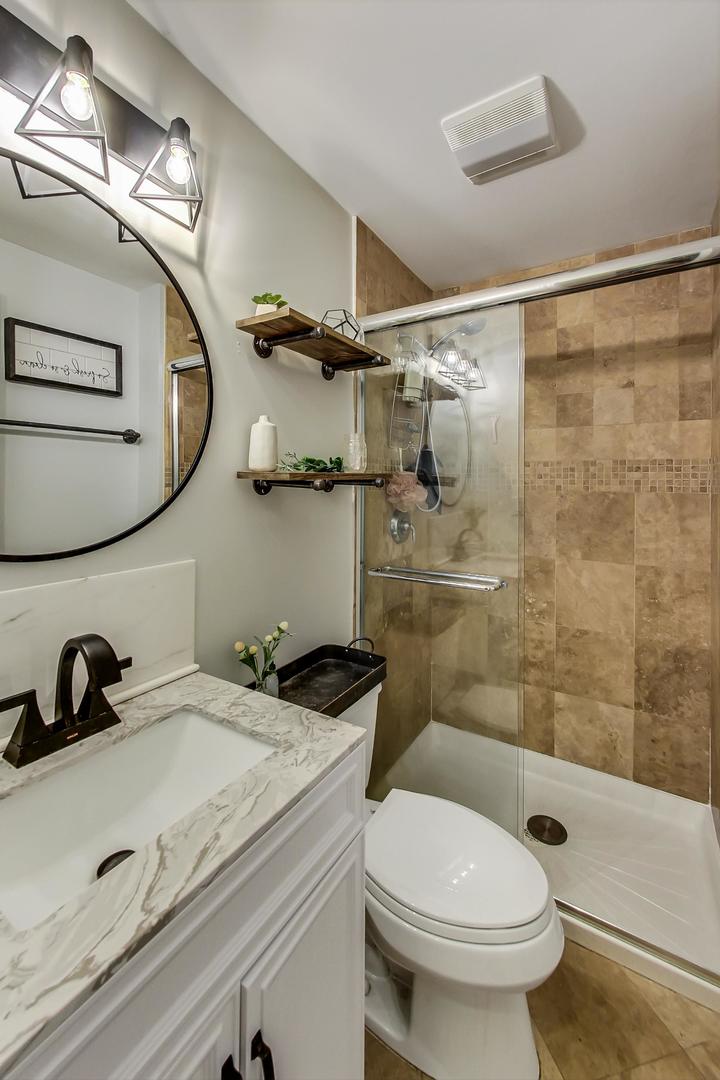 2142 West Addison Street, Unit 1A Chicago, IL 60618 - Photo 10 of 23 a bathroom with a sink a toilet and a shower