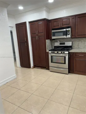 a kitchen with stainless steel appliances granite countertop a refrigerator microwave and sink