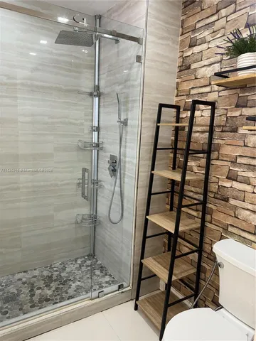 a bathroom with a toilet and a shower