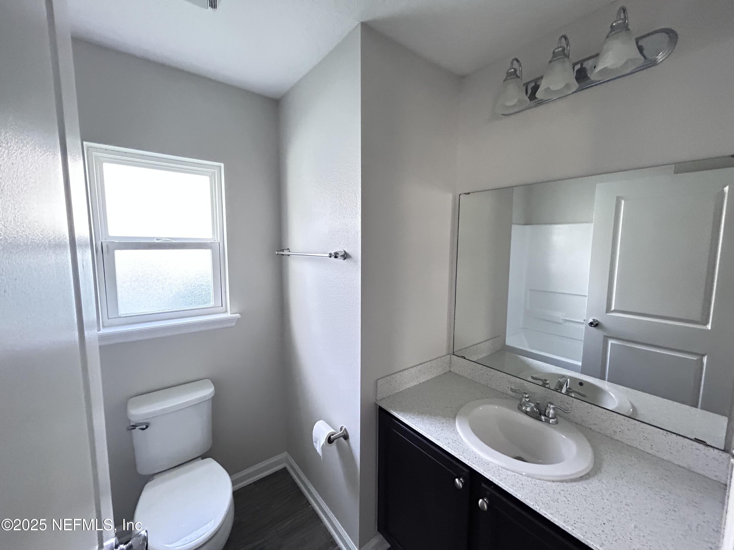 102 Bluejack Lane St. Augustine, FL 32095 - Photo 23 of 32 a bathroom with a granite countertop toilet a sink and mirror