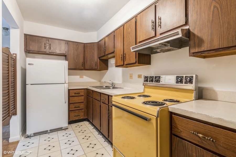 715 West Central Road, Unit B8 Mount Prospect, IL 60056 - Photo 4 of 10 a kitchen with a refrigerator sink stove and cabinets