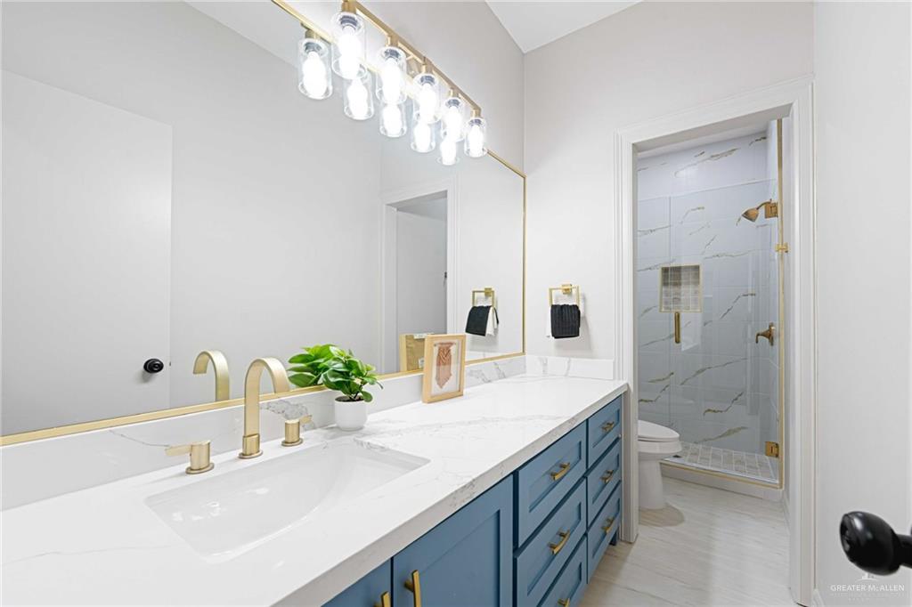 2216 South 45th Street McAllen, TX 78503 - Photo 21 of 34 a bathroom with a sink a toilet and a large mirror