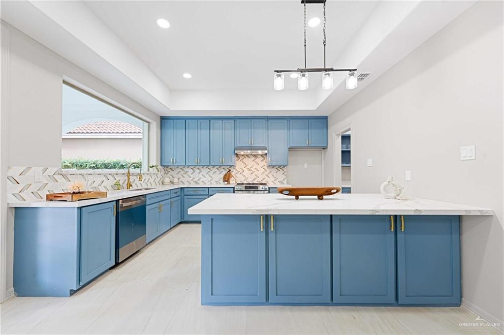 2216 South 45th Street McAllen, TX 78503 - Photo 10 of 34 a kitchen with a sink a stove a refrigerator and island