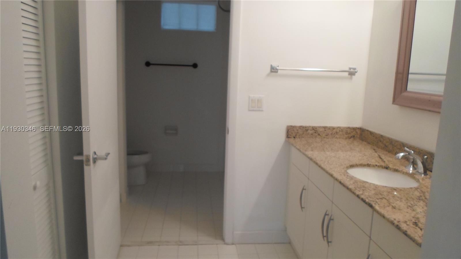 7275 Southwest 90th Way, Unit G 611 Miami, FL 33156 - Photo 13 of 56 a bathroom with a granite countertop sink mirror and vanity