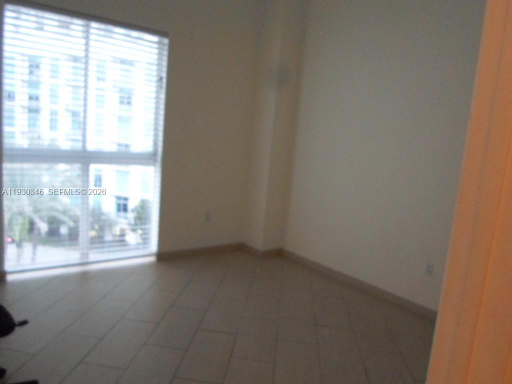 7275 Southwest 90th Way, Unit G 611 Miami, FL 33156 - Photo 30 of 56 a view of an empty room with wooden floor and a window