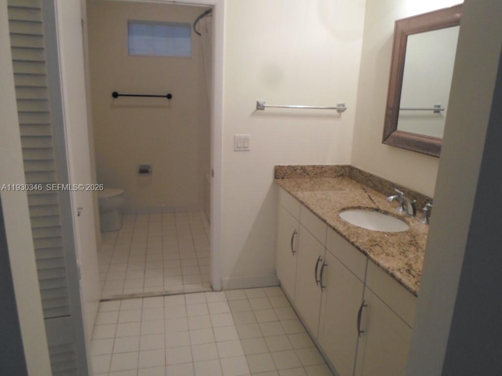 7275 Southwest 90th Way, Unit G 611 Miami, FL 33156 - Photo 33 of 56 a bathroom with a granite countertop sink and a mirror