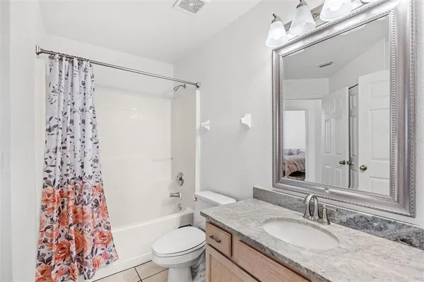 a bathroom with a granite countertop sink toilet shower and a mirror