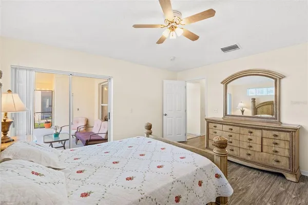 a bedroom with a bed a dresser and wooden floor