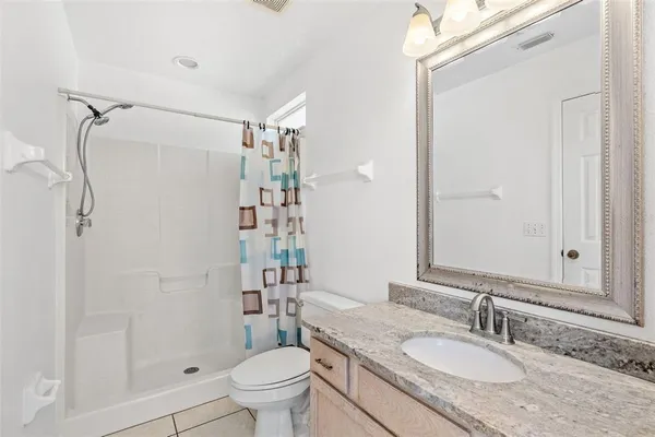 a bathroom with a granite countertop sink toilet and shower