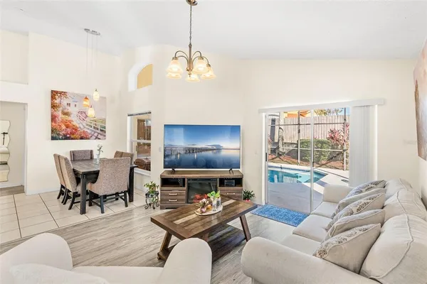 a living room with furniture a chandelier and a dining table