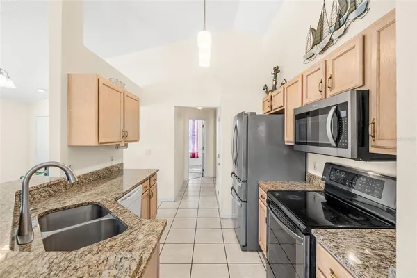 a kitchen with stainless steel appliances granite countertop a sink stove and refrigerator