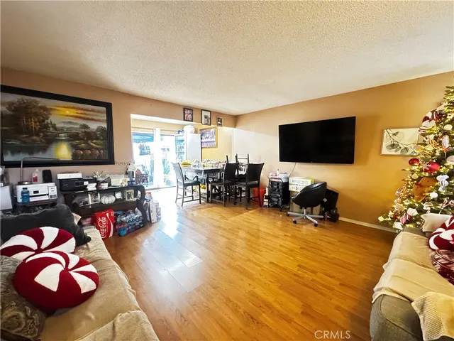 a living room with furniture and a flat screen tv with wooden floor