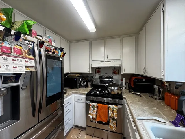 a kitchen with stainless steel appliances a stove a refrigerator and a sink