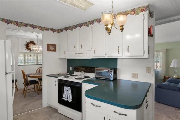 a kitchen with stainless steel appliances granite countertop a stove a refrigerator and a white cabinets