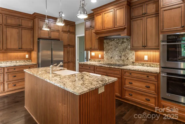 a kitchen with stainless steel appliances granite countertop a sink stove and refrigerator