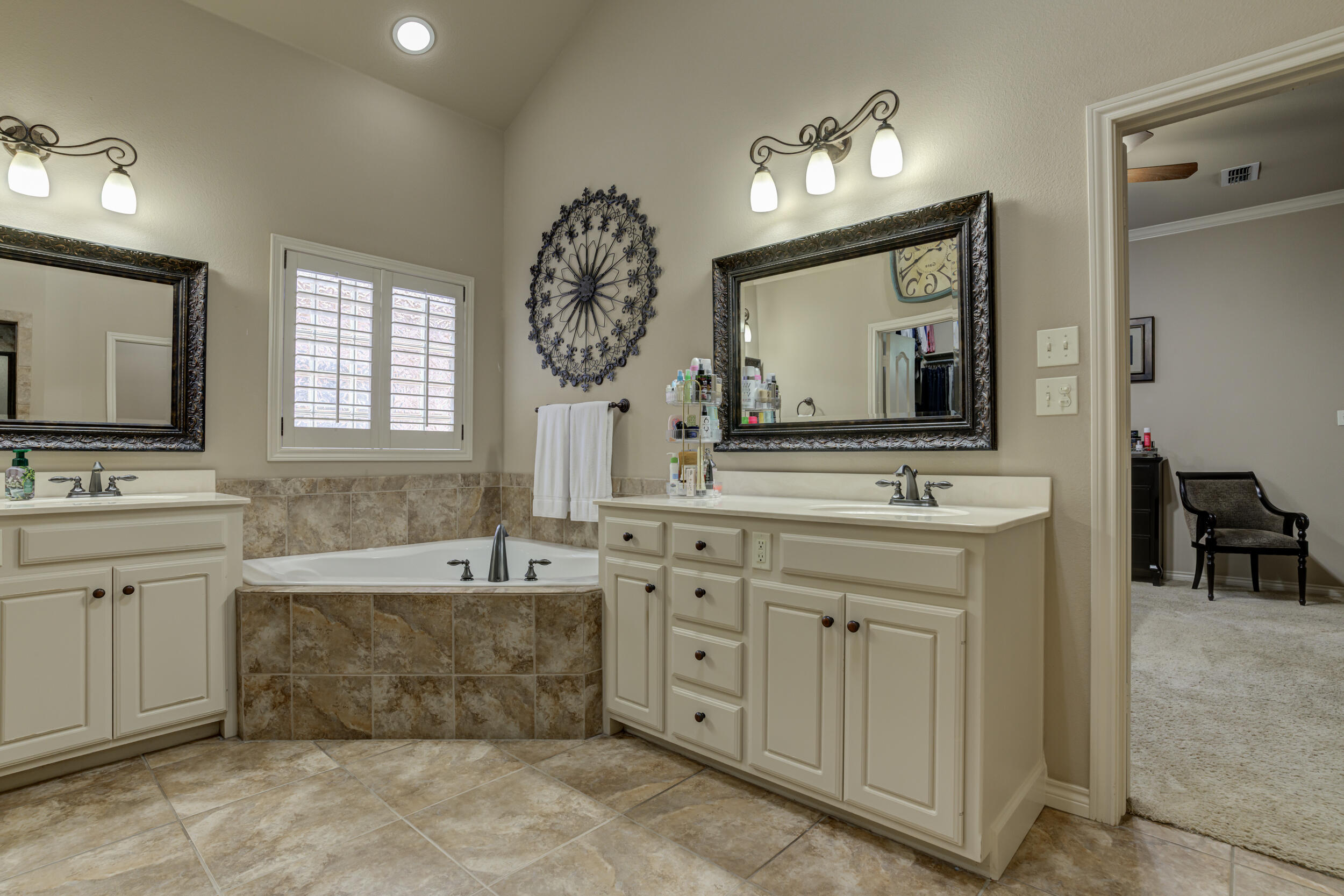 6008 89th Street Lubbock, TX 79424 - Photo 32 of 61 a bathroom with a sink mirror and a bathtub