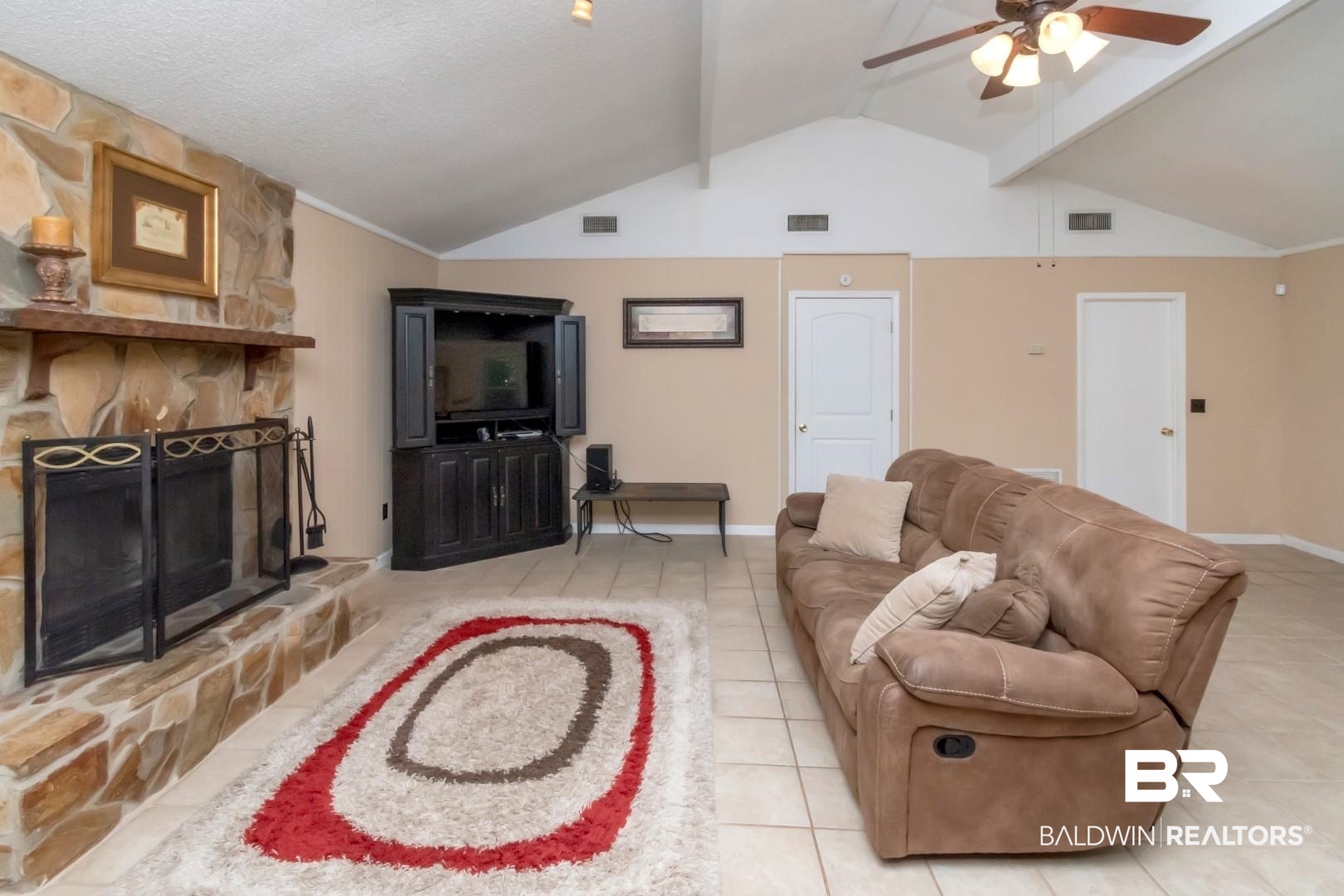 1321 Rainbow Drive West Mobile, AL 36693 - Photo 18 of 48 Tiled living room with ceiling fan, a stone fireplace, a textured ceiling, and high vaulted ceiling