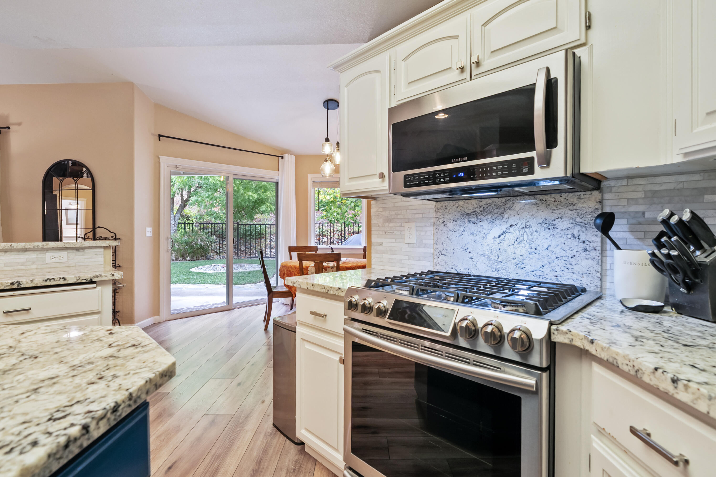 19219 Nike Court Redding, CA 96003 - Photo 7 of 37 a kitchen with granite countertop a stove and a wooden floor