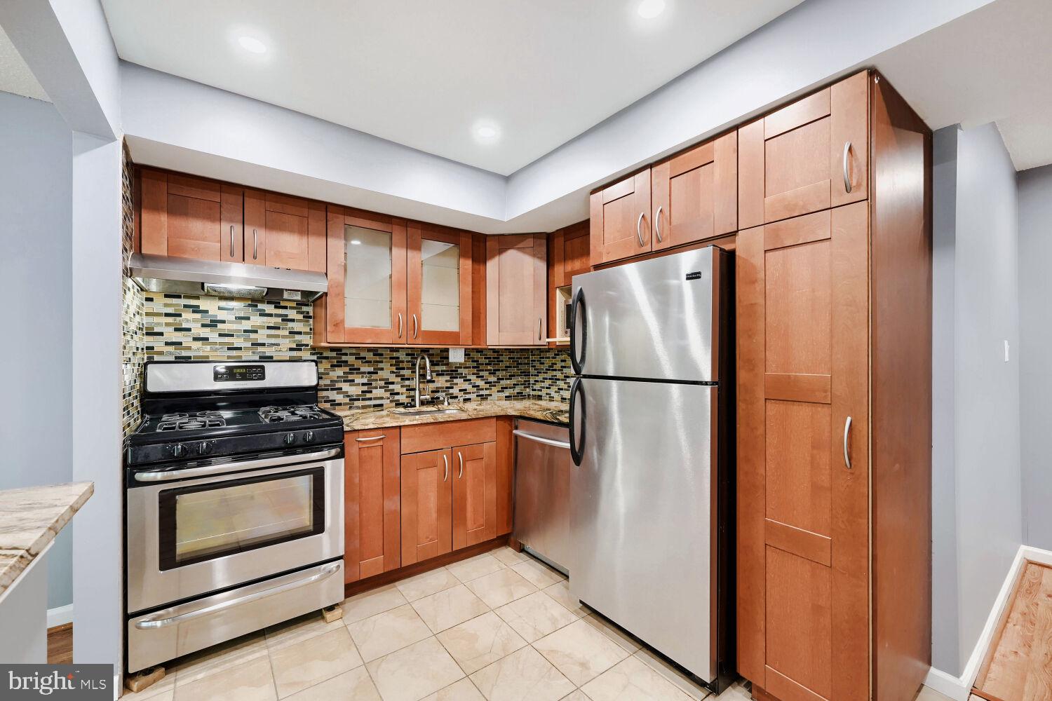 3 Windblown Court, Unit 102 Baltimore, MD 21209 - Photo 2 of 11 a kitchen with stainless steel appliances granite countertop a refrigerator sink and stove