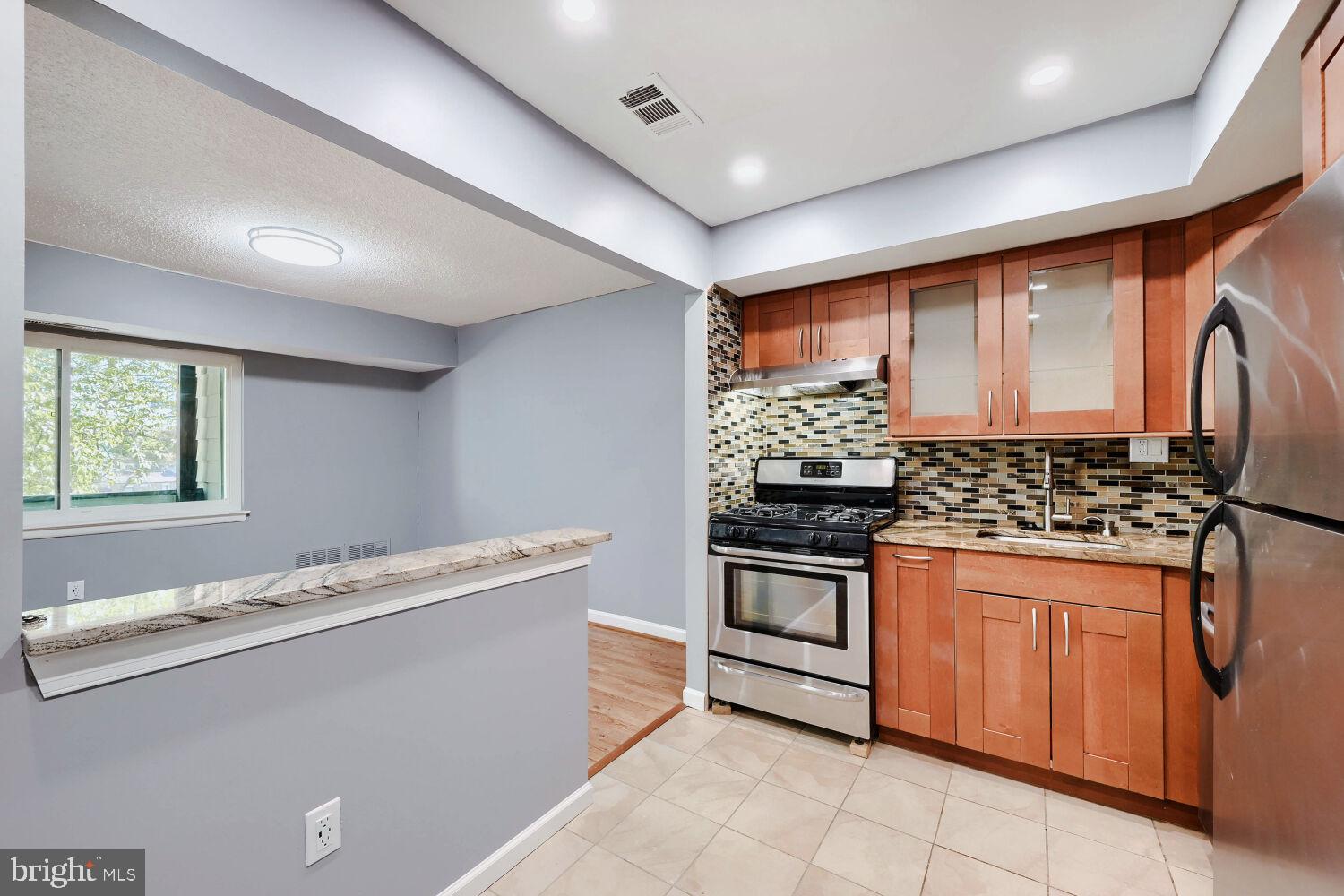 3 Windblown Court, Unit 102 Baltimore, MD 21209 - Photo 3 of 11 a kitchen with stainless steel appliances granite countertop a stove and a sink
