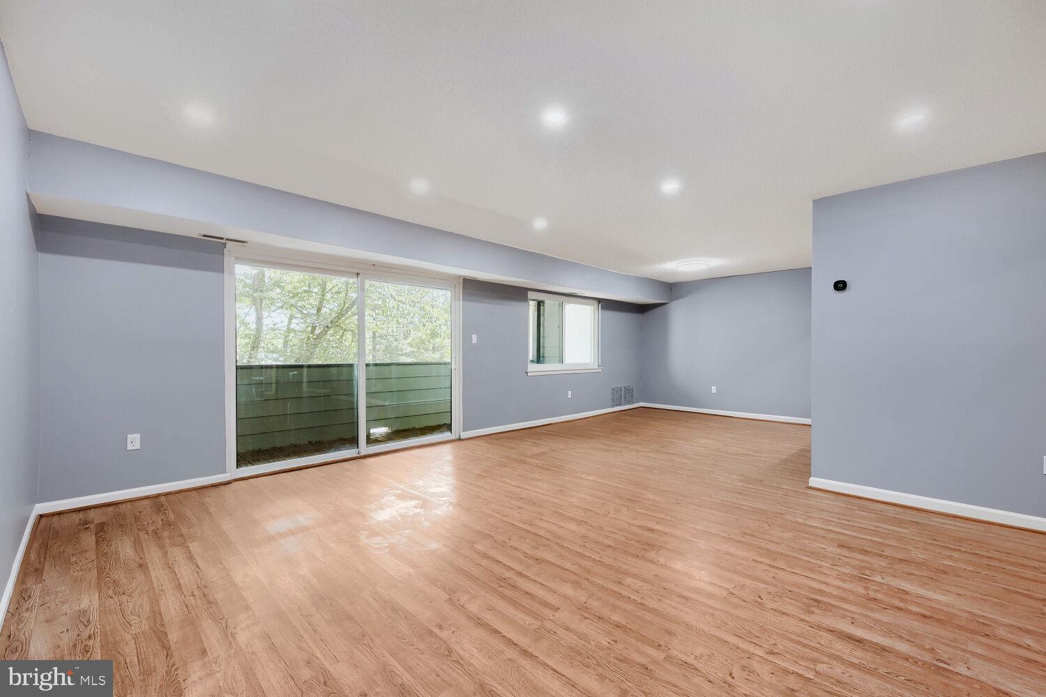 3 Windblown Court, Unit 102 Baltimore, MD 21209 - Photo 6 of 11 a view of an empty room with wooden floor and a window