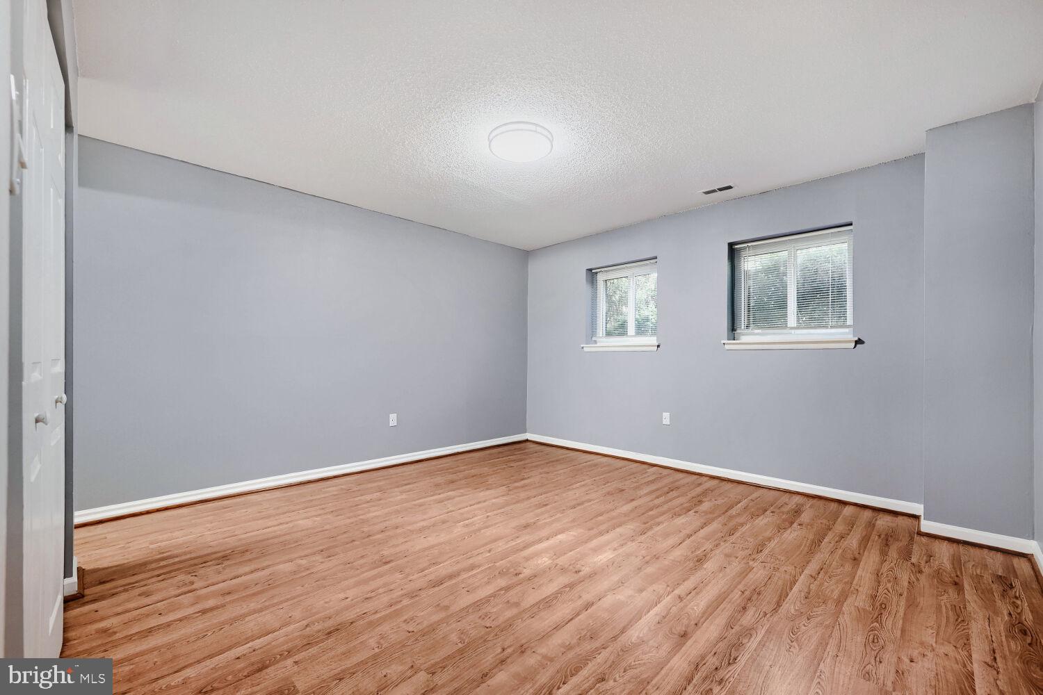 3 Windblown Court, Unit 102 Baltimore, MD 21209 - Photo 7 of 11 an empty room with wooden floor and windows