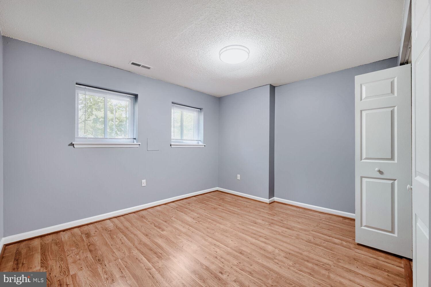 3 Windblown Court, Unit 102 Baltimore, MD 21209 - Photo 9 of 11 an empty room with wooden floor and windows