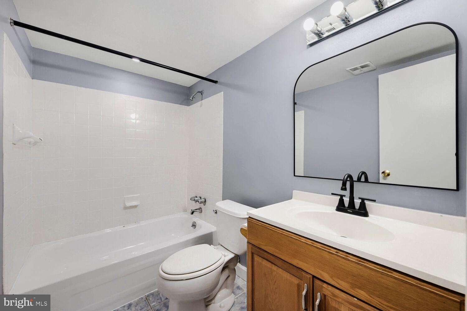 3 Windblown Court, Unit 102 Baltimore, MD 21209 - Photo 10 of 11 a bathroom with a sink a toilet a mirror and shower
